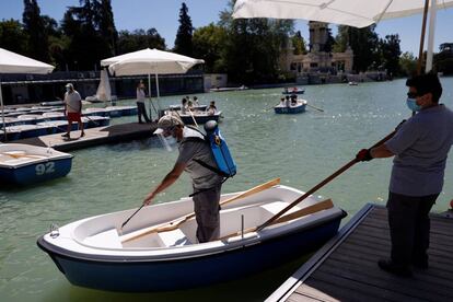 Un operario desinfecta una de las barcas del parque del Retiro, en Madrid, esta semana.