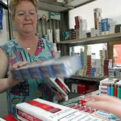 Una estanquera dispensa cajetillas de tabaco