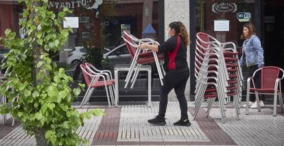 Una camarera prepara la terraza de una cervecería, en Navarra.