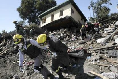 Varios bomberos chilenos trabajan sobre un área afectada por el temblor de tierra y el <i>tsunami,</i> el pasado jueves en el municipio de Constitución.