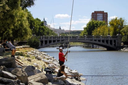 Una familia pasa el domingo pescando en el río Manzanares a la altura del Puente de la Reina Victoria.