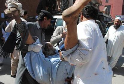 Traslado de un herido en el ataque suicida durante un cortejo fúnebre en Peshawar (Pakistán).