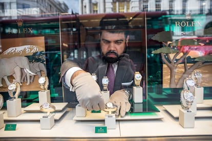 Un empleado manipula un reloj Rolex en una tienda de Londres.  