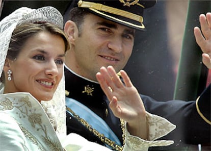 Los novios saludan, durante el recorrido del cortejo nupcial por las calles de Madrid.