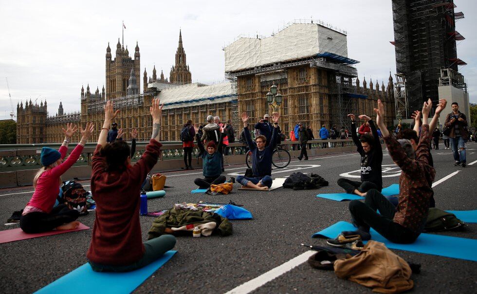 Un grupo de activistas practican yoga en el puente de Westminster durante la protesta de Extinction Rebellion en Londres.