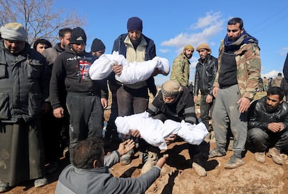 Varios hombres trasladan los cuerpos de varias víctimas de los terremotos durante su funeral en la ciudad de Jandaris (Siria) este miércoles.