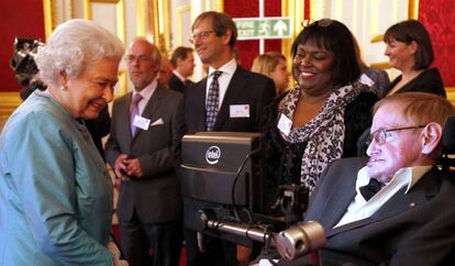 Stephen Hawking junto a su enfermera, Patricia Dowdy, durante una visita a Isabel II en el Palacio de Buckingham en 2014.