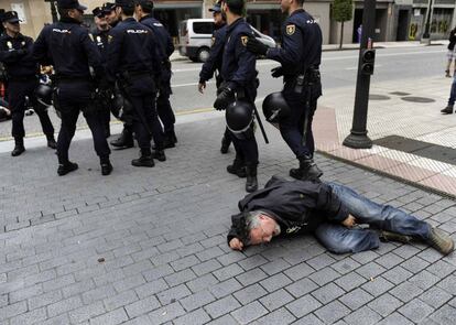 Un activista se lamenta en el suelo tras ser retirado por la policía durante una protesta en Oviedo.