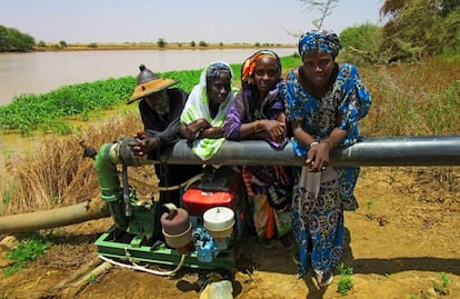 Djiby Ly, Djenaba Demba, Binta Cámara y Aminata Ba junto al río Doué y la bomba que extrae el agua para conducirlo a su huerto, en Guedé.