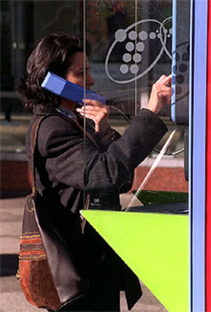 Una ciudadana habla a través de una cabina telefónica.