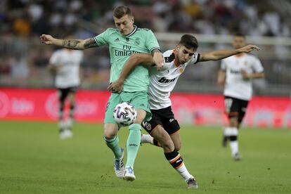 El centrocampista del Valencia Ferrán Torres, a la izquierda, pelea un balón con el centrocampista alemán del Real Madrid Toni Kroos.