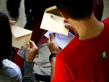 Una pareja con las papeletas para votar en un colegio electoral de Madrid el pasado mayo.