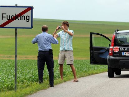 Dos turistas se hacen una fotografía junto a una señal del pueblo de Fucking (Austria).