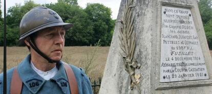 Un miembro de una asociación de memoria de la I Guerra Mundial vestido de 'poilu' junto a un monumento en homenaje a varios soldados fusilados.