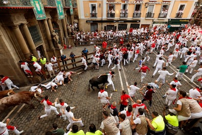 Corredores a su paso por la plaza del Ayuntamiento de Pamplona, este jueves durante el quinto encierro de San Fermín. 