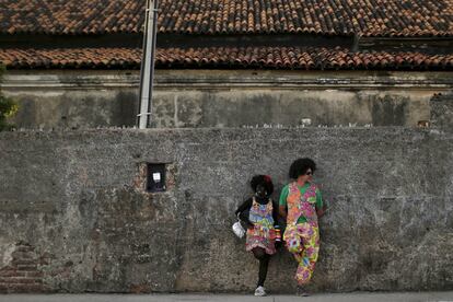 Dos personas disfrazadas se apoyan en una pared de una vivienda, en Oliva (Brasil).