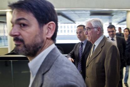 Oriol Pujol, en primer término, y el diputado Jordi Turull flanqueando la entrada de Daniel Osácar, ayer, en la Ciudad de la Justicia.