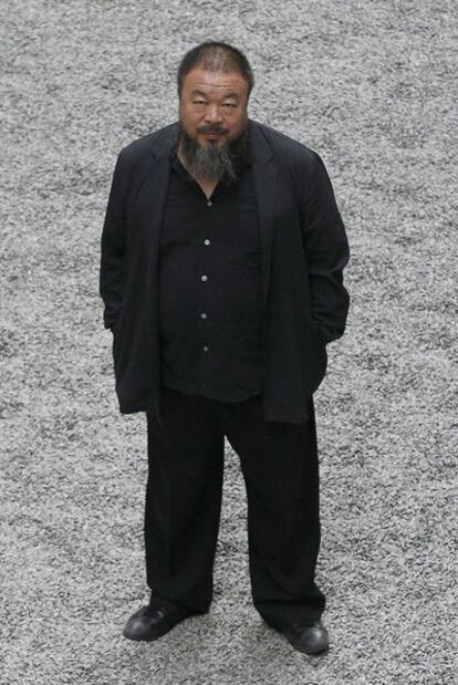 El artista chino Ai Weiwei posa sobre la instalación de su obra titulada <i>Pipas de girasol, </i>en la galería londinense Tate Modern.