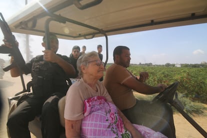 A group of militia members transport an elderly Israeli woman captured in the Kfar Azza kibbutz, in Israel, on September 7, 2023, in the Gaza Strip.