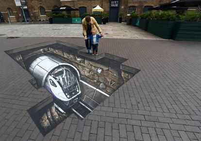 Un padre junto a su hijo observan una obra de arte 3D en el museo Docklands en Londres (Reino Unido).