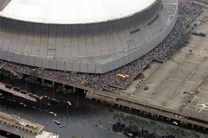 Miles de personas congregadas en los alrededores del estadio Superdome de Nueva Orleans esperan su evacuación.
