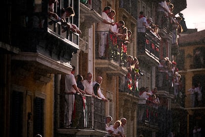 Deelnemers wachten vanaf hun balkons op de start van de stierenrennen, komende maandag, in een van de straten van Pamplona.