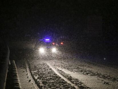 Un veh&iacute;culo de emergencias transita por una carretera nevada,