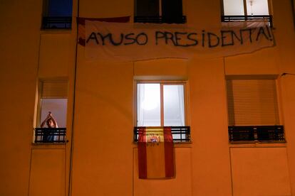 Vecinos celebran la victoria de Ayuso en el edificio de enfrente de la sede del PSOE en la calle Ferraz de Madrid.