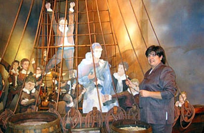Susana Ramírez junto a la reproducción del barco con los niños de la vacuna, en la exposición de A Coruña.