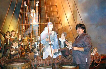 Susana Ramírez junto a la reproducción del barco con los niños de la vacuna, en la exposición de A Coruña.