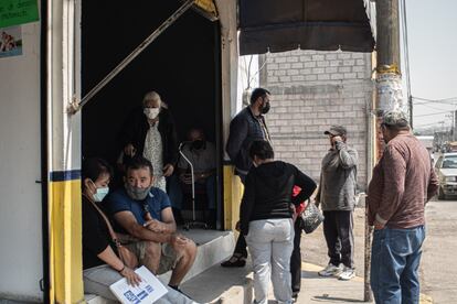 Pacientes y acompañantes en la sala de espera de clínica durante pandemia del coronavirus