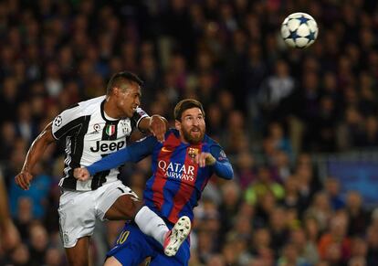 Lionel Messi (derecha) y Alex Sandro siguen con la mirada la trayectoria del balón.