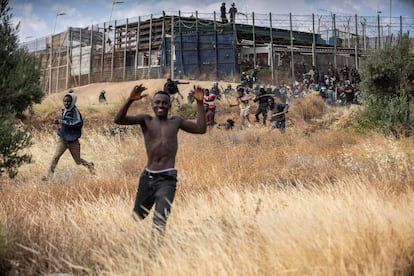 Migrantes subsaharianos corren nada más saltar la valla fronteriza de Melilla. 