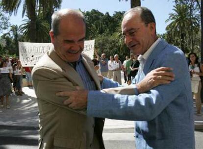 Chaves y De la Torre se saludan antes de la reunión. Detrás, una protesta de estudiantes.