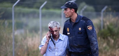 A police officer escorts Francisco Garzón, the train driver on the crashed Alvia, moments after the accident.
