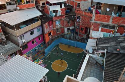 Um grupo de crianças joga futebol em um campo na favela de Tavares Bastos, no Rio de Janeiro (Brasil).