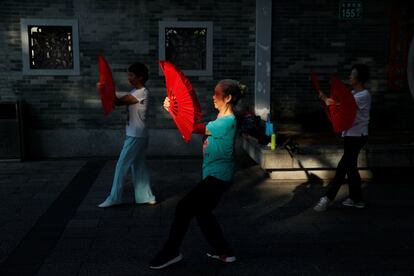 Las mujeres practican tai-chi temprano en la mañana en un parque en el distrito antiguo de la ciudad de Liwan en Guanghzou. Es una costumbre que los mayores practiquen'tai chi' y bailen juntos para hacer ejercicio en compañía en los espacios públicos.