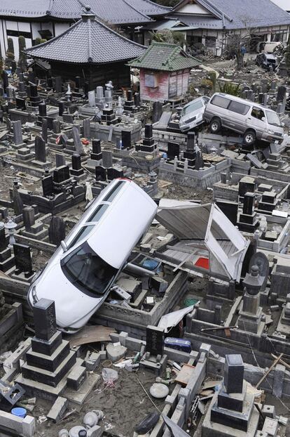 Vehículos arrastrados por el tsunami, en medio de un cementerio de Ishinomaki, Miyagi.