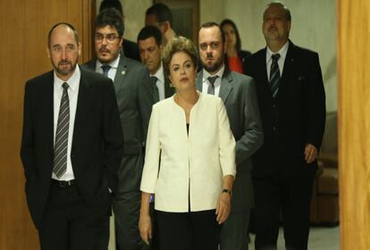 Cercada de assessores e membros do governo, a presidenta Dilma Rousseff se prepara para pronunciamento à imprensa no Palácio do Planalto após o presidente da Câmara dos Deputados, Eduardo Cunha, anunciar que acolheu o pedido de impeachment contra ela.