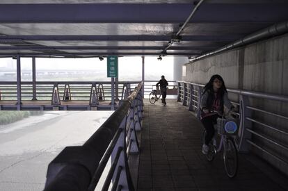 Bajo una carretera que cruza el río Xindian (Taipei), usuarios de bicicletas de alquiler que se pueden adquirir en diferentes puntos de sus orillas, entre Taipei y New Taipei City.