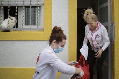 Personal de Cruz Roja de Cataluña se encarga de repartir en domicilios cada día comida y medicamentos a personas en situación vulnerable. En la imagen Cristina, voluntaria de Cruz Roja, durante el reparto en Barcelona.