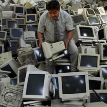 Un hombre rodeado de pantallas de ordenador para reciclar