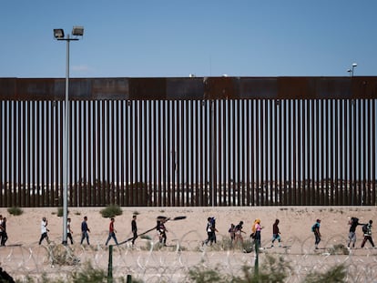 Un grupo de migrantes camina junto al muro en Ciudad Juárez (Estado de Chihuahua), el 5 de octubre.
