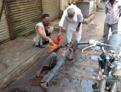 Vários moradores de Karachi, coração econômico do Paquistão, ajudam idoso a se hidratar. Somente no hospital Jinnah de Karachi, capital da província de Sindh, 415 pessoas morreram em quatro dias por conta da forte onda de calor. Mas, em todo o país, número de mortos já passa de 1.000, segundo informações da agência Reuters.