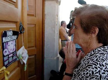 Una mujer reza frente a la puerta de la parroquia de Lagos, donde el sábado se celebró una misa por Madeleine.