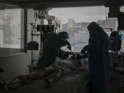 Dos sanitarios atienden a un paciente con covid en la UCI del Hospital de Bellvitge de Barcelona.