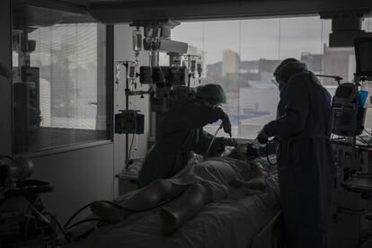 Dos sanitarios atienden a un paciente con covid en la UCI del Hospital de Bellvitge de Barcelona.