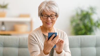 Una mujer mayor utilizando un móvil en su casa.