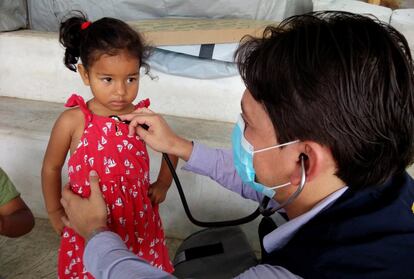 El doctor Carlos Tello Ponce ausculta a una niña. Tras el terremoto, su centro de salud sale a la calle para hacer revisiones a los vecinos de las zonas afectadas.