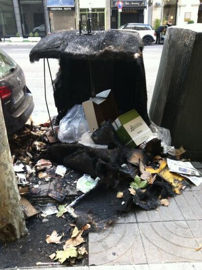 Un contenedor quemado con la basura desparramada a su alrededor. La foto es de José Piquer. https://twitter.com/frangalive